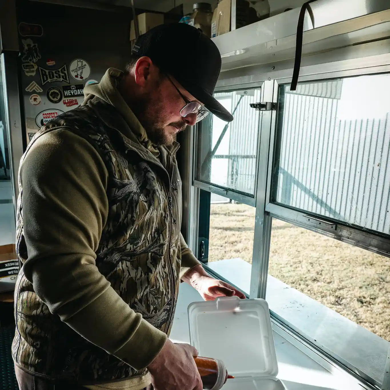 Hunter in black hat inside hunting blind