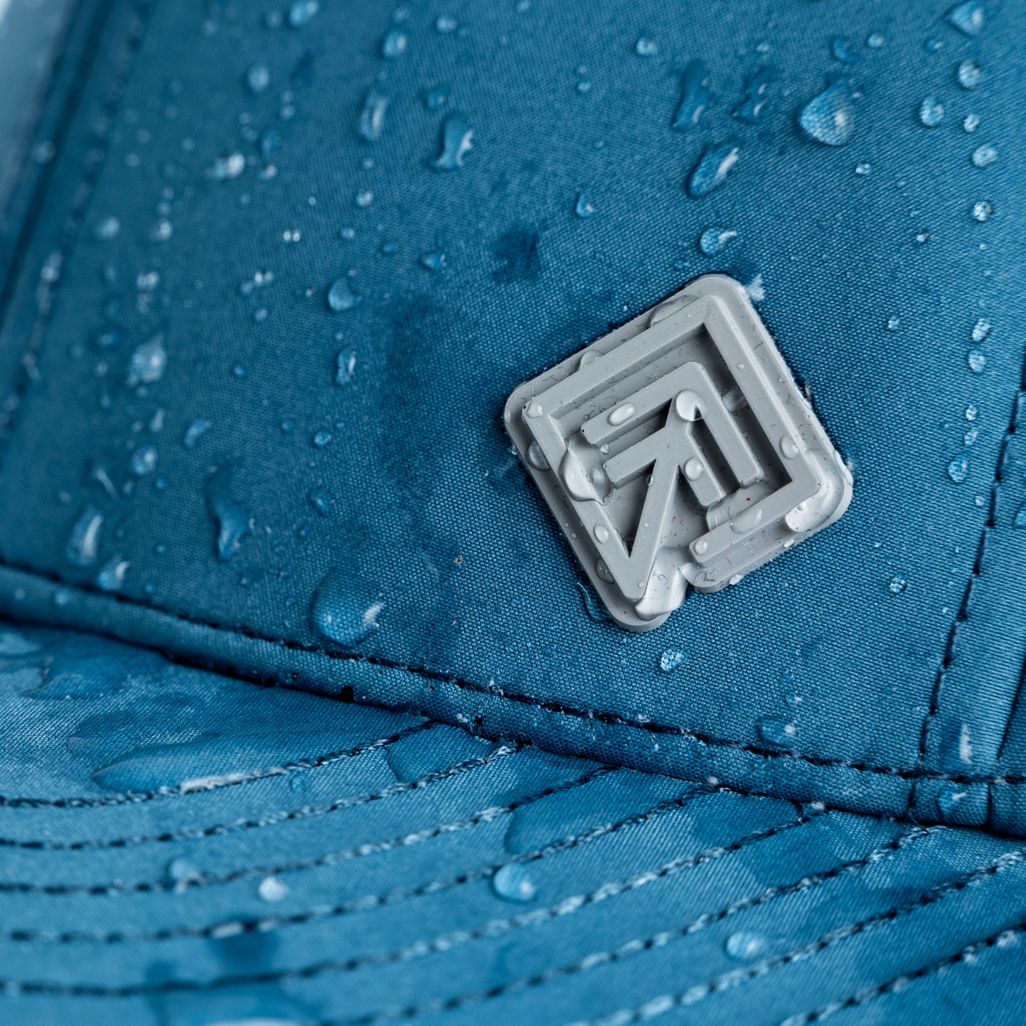 Water beading on blue Terreno hat logo