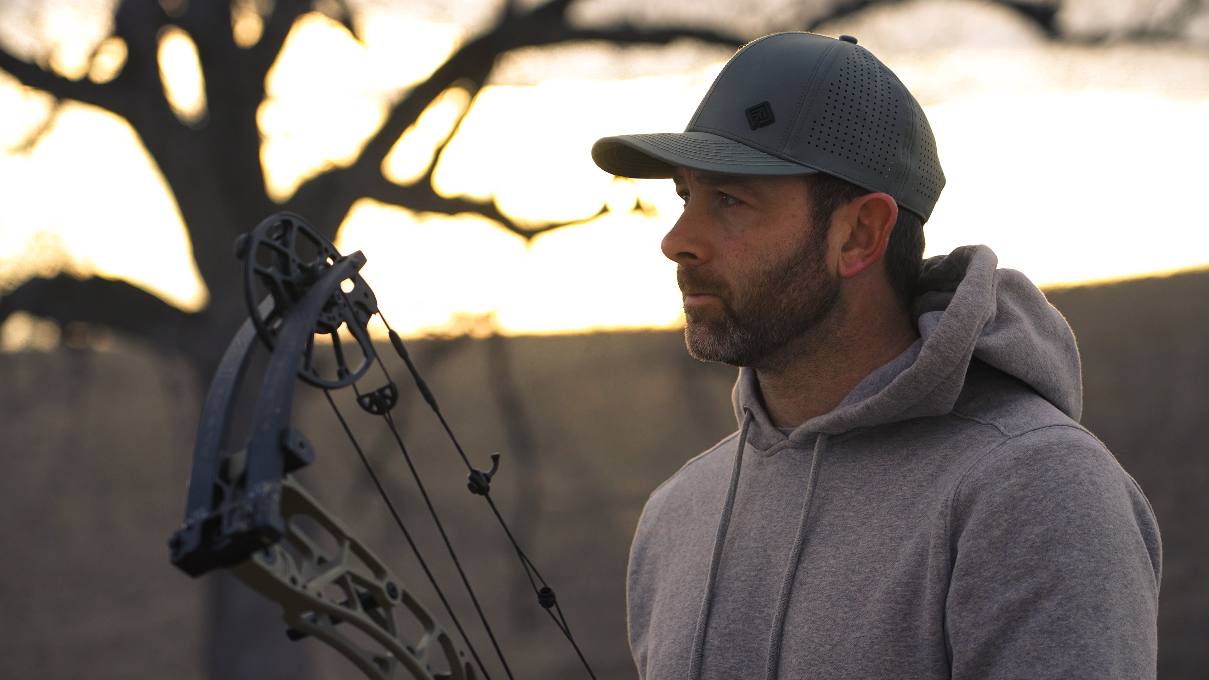 Bowhunter in grey Terreno hat at dusk