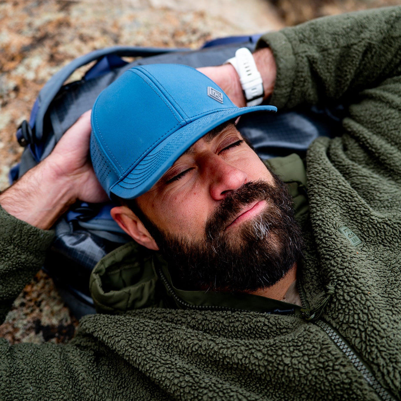 Man resting outdoors in blue hat