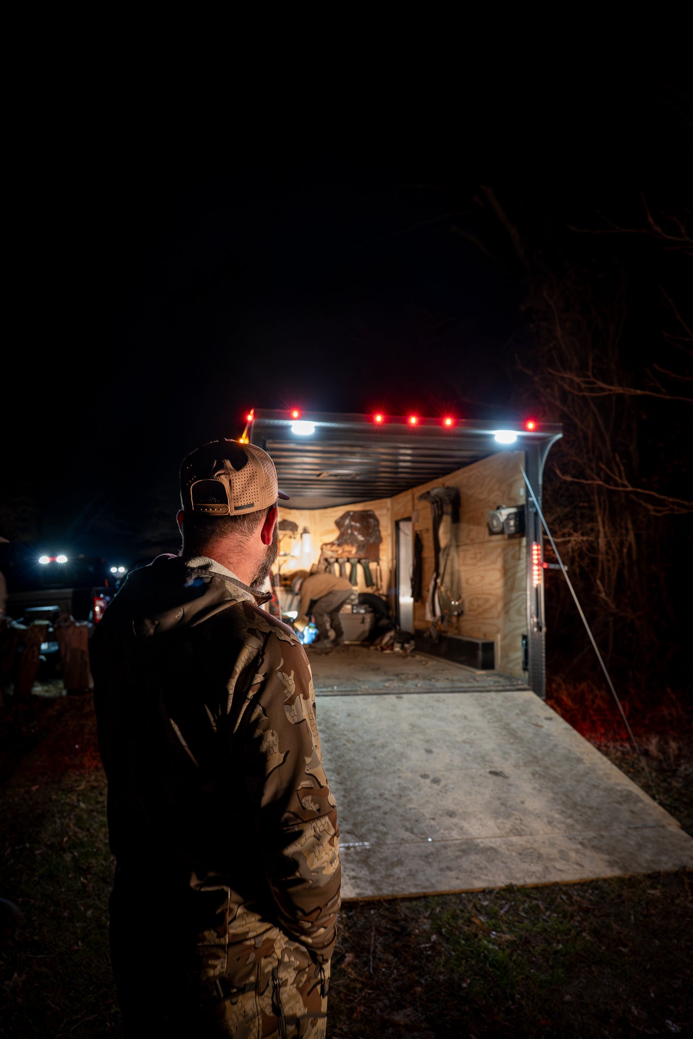 Hunter in hat at night by trailer