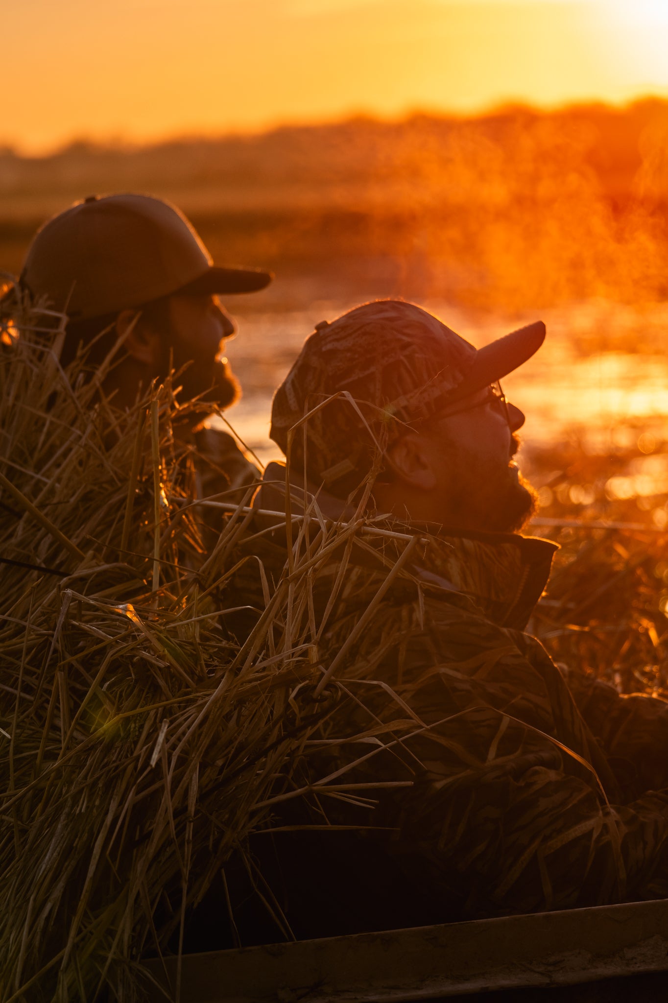 Two hunters in hats at sunrise