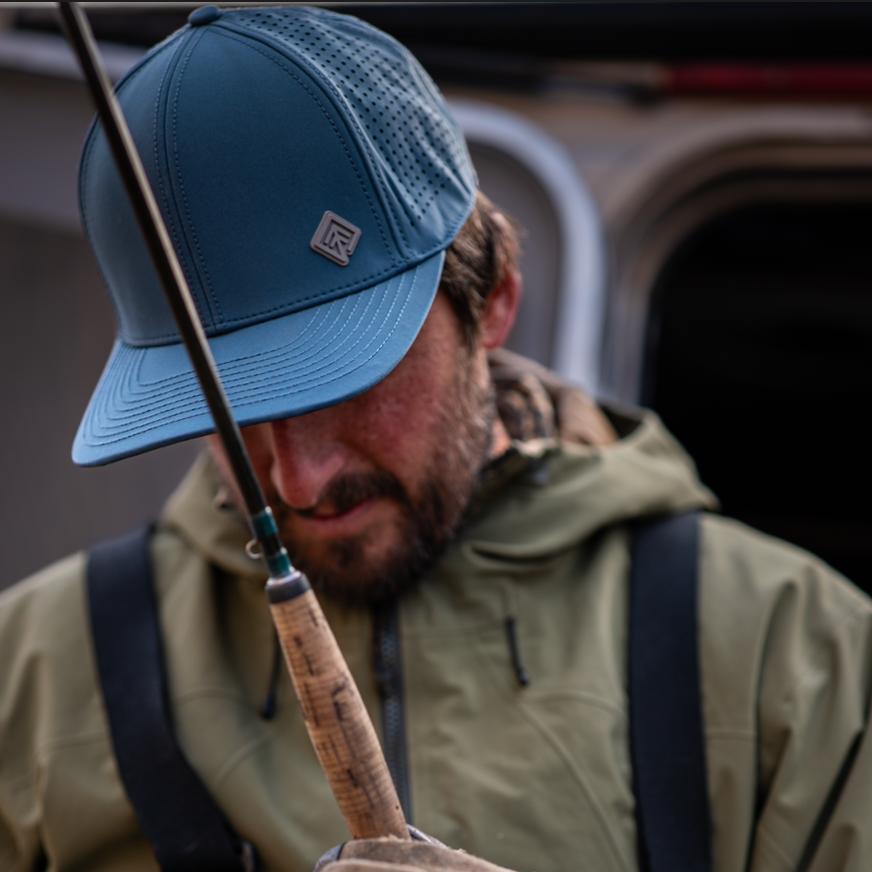 Fisherman in blue hat holding rod